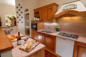 a kitchen with wooden cabinets and a counter with a bottle of wine at Villa La Paleotta in Fano