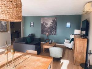 a living room with a couch and a table at Le Jas de Joucas Hôtel-Restaurant in Joucas