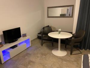 a living room with a table and a tv and chairs at Apartment Hannover in Hannover