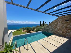 ein Swimmingpool mit Blick auf das Meer in der Unterkunft Colonides Retreat Sea & Silence in Vounaria