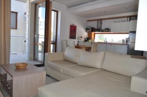 ein Wohnzimmer mit einem weißen Sofa und einer Küche in der Unterkunft Beautiful family villa with sea view in Byala