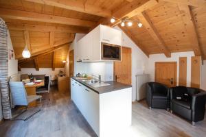 cocina y sala de estar con techos de madera en Göllerhof, en Caldaro