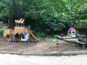 a playground with a play set and a slide at Camping Moulin De Chaules in Saint-Constant