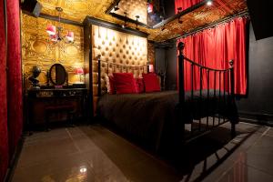 a bedroom with a bed and a red curtain at Brighton Erotic Boudoir in Brighton & Hove