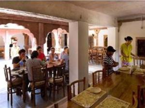 a group of people sitting at a table in a restaurant at Chandelao Garh in Bīnāwās