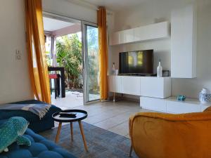 ein Wohnzimmer mit einem Sofa und einem TV in der Unterkunft villa dans lo in Le Moule