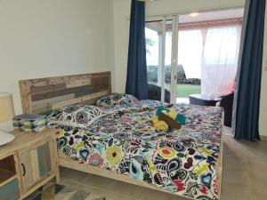 ein Schlafzimmer mit einem Bett mit einer bunten Bettdecke in der Unterkunft villa dans lo in Le Moule