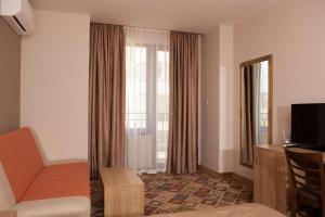 a hotel room with a chair and a window at Hotel Motto in Stara Zagora