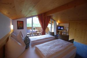 a hotel room with two beds and a dining room at Hotel-Pension Heike in Kitzbühel