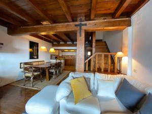 a living room with a white couch and a cross on the wall at Rustic Chic de Luxe 55C in El Tarter