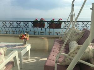 a balcony with a couch and a table with flowers at Trabzon Sea Pearl in Trabzon