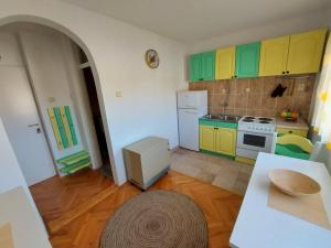 a small kitchen with green and yellow cabinets at Apartman Bregovi in Trebinje +9 photos
