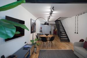 a living room with a table and a staircase at FLH Intendente Industrial Design Duplex in Lisbon