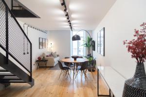 a dining room and living room with a table and chairs at FLH Intendente Industrial Design Duplex in Lisbon