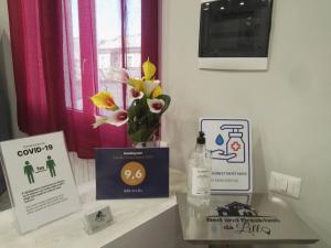 a table with a vase of flowers and signs on it at B&B da Lillo in Frosinone