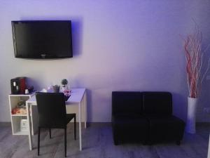 sala de estar con mesa y TV en la pared en B&B da Lillo, en Frosinone