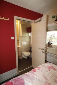 a bathroom with a bed and a toilet in a room at Park Atlantis De Haan in De Haan