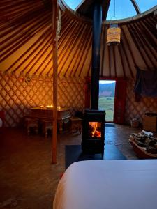 a room with a fireplace and a bed in a tent at Domaine des Planesses in Ferdrupt