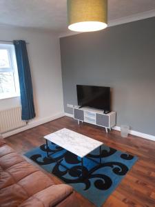 a living room with a couch and a flat screen tv at Comfortable 2 Bed Apartment 2nd Floor Contractors Families Close To City Centre Occasional Bed Available in Coventry