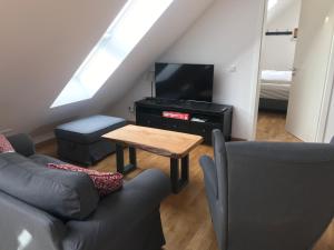 a living room with a couch and a tv and a table at Gästehaus Lausnitz Ferienwohnung, Reda in Lausnitz