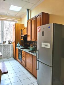 モスクワにあるHostel U Bashnyのキッチン(ステンレス製の冷蔵庫、木製キャビネット付)