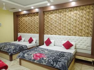 哈里瓦Hotel vinayak inn的房间里有两张床，还有红色枕头