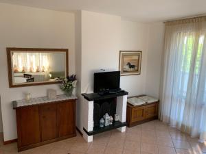 a living room with a fireplace and a mirror at Appartamento con terrazza panoramica in Forte dei Marmi