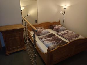 a bedroom with a wooden bed with two pillows at Sonnenhof in Weilmünster