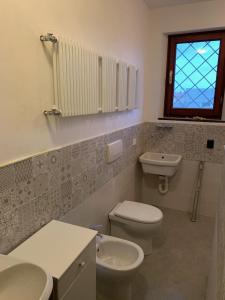ein Bad mit einem Waschbecken, einem WC und einem Fenster in der Unterkunft Appartamento con terrazza panoramica in Forte dei Marmi