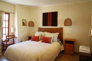 a bedroom with a large bed with two red pillows at Terrace Lodge in Putre