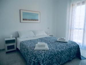 a bedroom with a bed with a blue and white blanket at Casa Nica in Modica