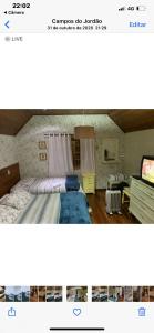 a picture of a bedroom with a bed and a tv at Casa em Campos do Jordão in Campos do Jordão