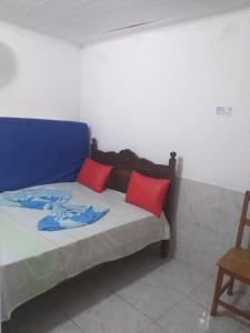 Casa em Gamboa في غامبوا: سرير مع وسائد حمراء وزرقاء في الغرفة