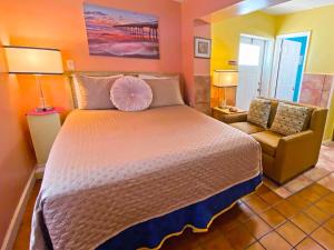 um quarto com uma cama grande e uma cadeira em Bella Sirena Inn em St. Pete Beach