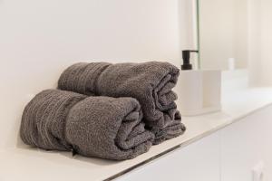 a pile of towels sitting on a shelf in a bathroom at NorthApartments Chemnitz in Chemnitz