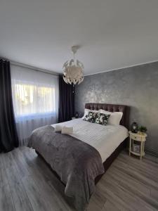 Un dormitorio con una cama grande y una lámpara de araña. en Apartament Central Iulia, en Sibiu 14 fotos más