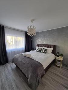 a bedroom with a large bed and a chandelier at Apartament Central Iulia in Sibiu