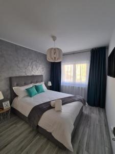 Un dormitorio con una cama grande con cortinas azules. en Apartament Central Iulia, en Sibiu