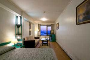 イスタンブールにあるカドゥイチョイ ルフトム ホテルのベッドとリビングルームが備わるホテルルームです。