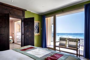 a bedroom with a large window with a view of the ocean at Stella Maris in Villasimius