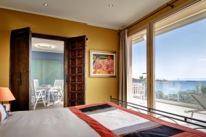 a bedroom with a bed and a large window at Stella Maris in Villasimius