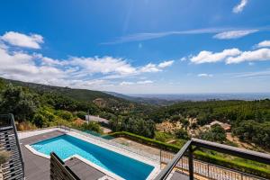 uitzicht op een zwembad vanaf het balkon van een huis bij Villa Monchique in Monchique