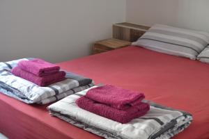 2 camas con toallas rosas encima en Maspalomas Experience Holiday House en Maspalomas