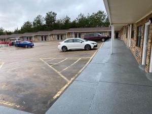 a white car parked in a parking lot next to a building at Town House Motel in Tyler