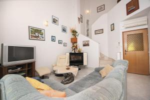 a living room with a blue couch and a tv at Miran apartments Pisak in Pisak