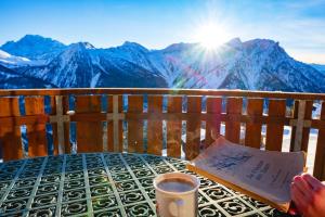 una persona sentada en una mesa con una taza de café en Chalet Bergkristall, en Rosswald