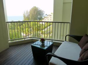 a room with a balcony with a view of the ocean at PARKROYAL Penang Resort in Batu Ferringhi