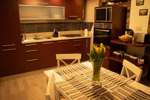 a kitchen with a table with a vase of flowers on it at La Podul Cetatii in Făgăraş