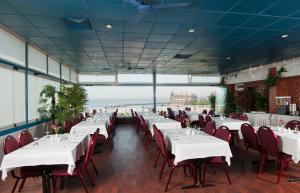 a dining room with white tables and red chairs at Kadıköy Rıhtım Hotel in Istanbul