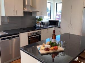 a kitchen with a counter with a cutting board and a bottle of wine at Kurow House on Bledisloe - A2O Cycle Trail Oasis. in Kurow